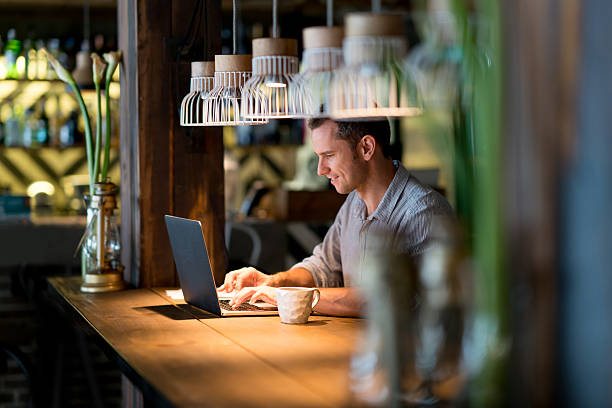 Man met laptop in bar